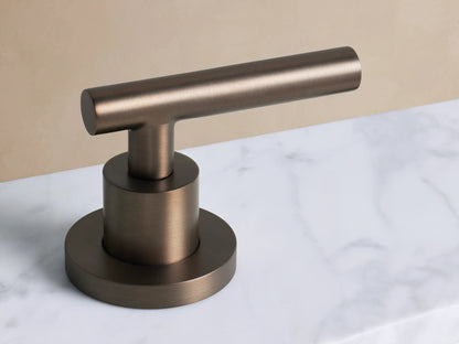 Crewe Smooth Faucet in Antique Bronze. Gooseneck spout with round base on white marble, subtle veins, against beige wall.