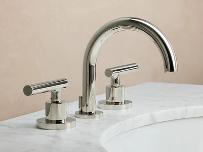Polished nickel Crewe Smooth Faucet with curved spout and two cylindrical handles, mounted on a marble countertop.