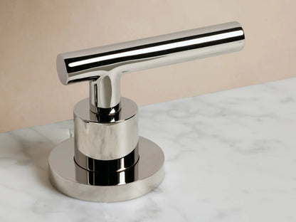 Polished nickel Crewe Smooth Faucet with cylindrical base and T-shaped handle, resting on marble surface.
