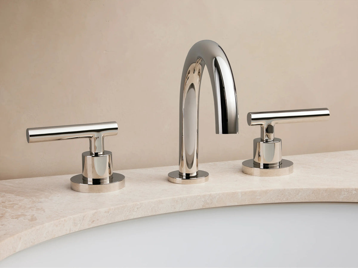 Crewe Smooth Faucet with polished nickel finish on marble counter, features sleek, curved spout and two cylindrical handles.