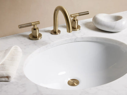 Circular pop-up drain in antique brass finish, featuring a smooth knurled design, set against a white surface.