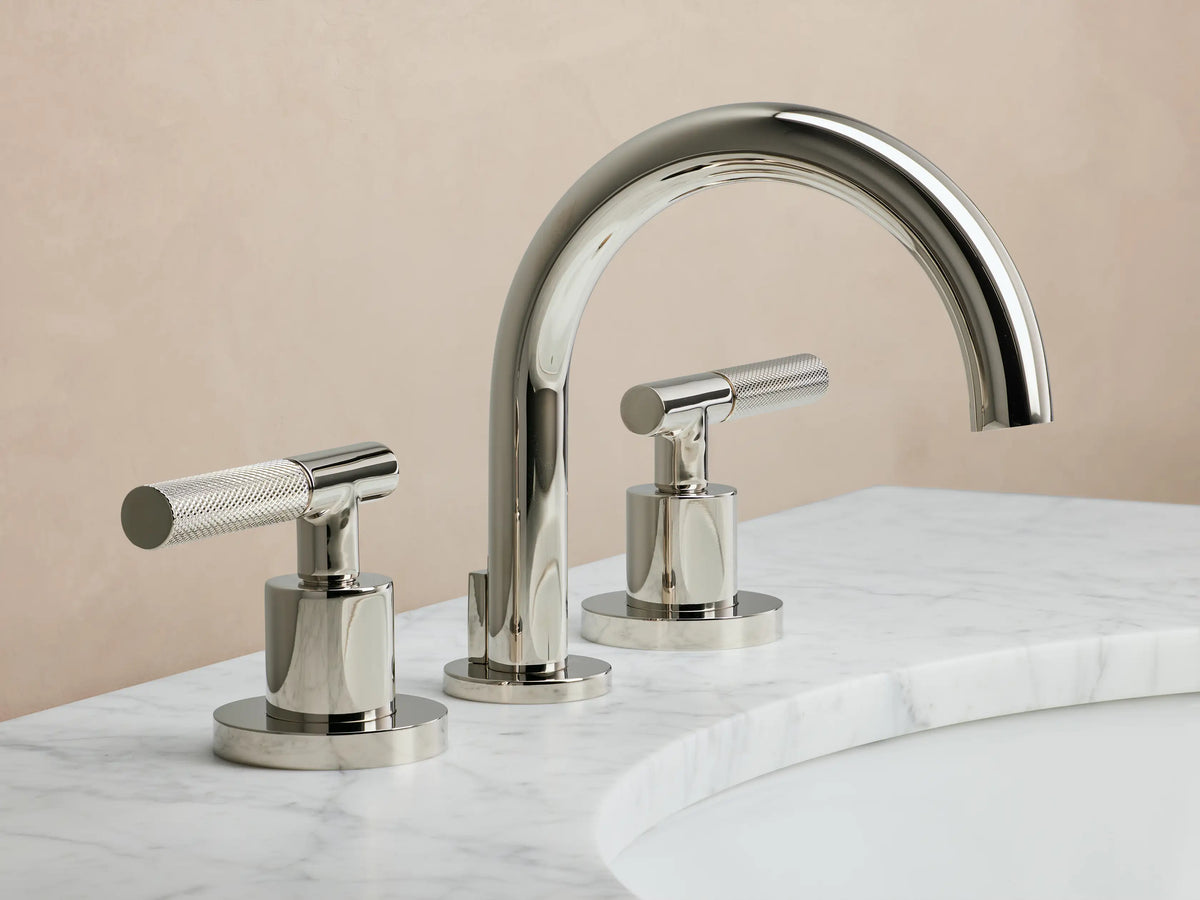 Crewe Knurled Faucet in polished nickel, featuring a curved spout and two cylindrical handles on a marble countertop.