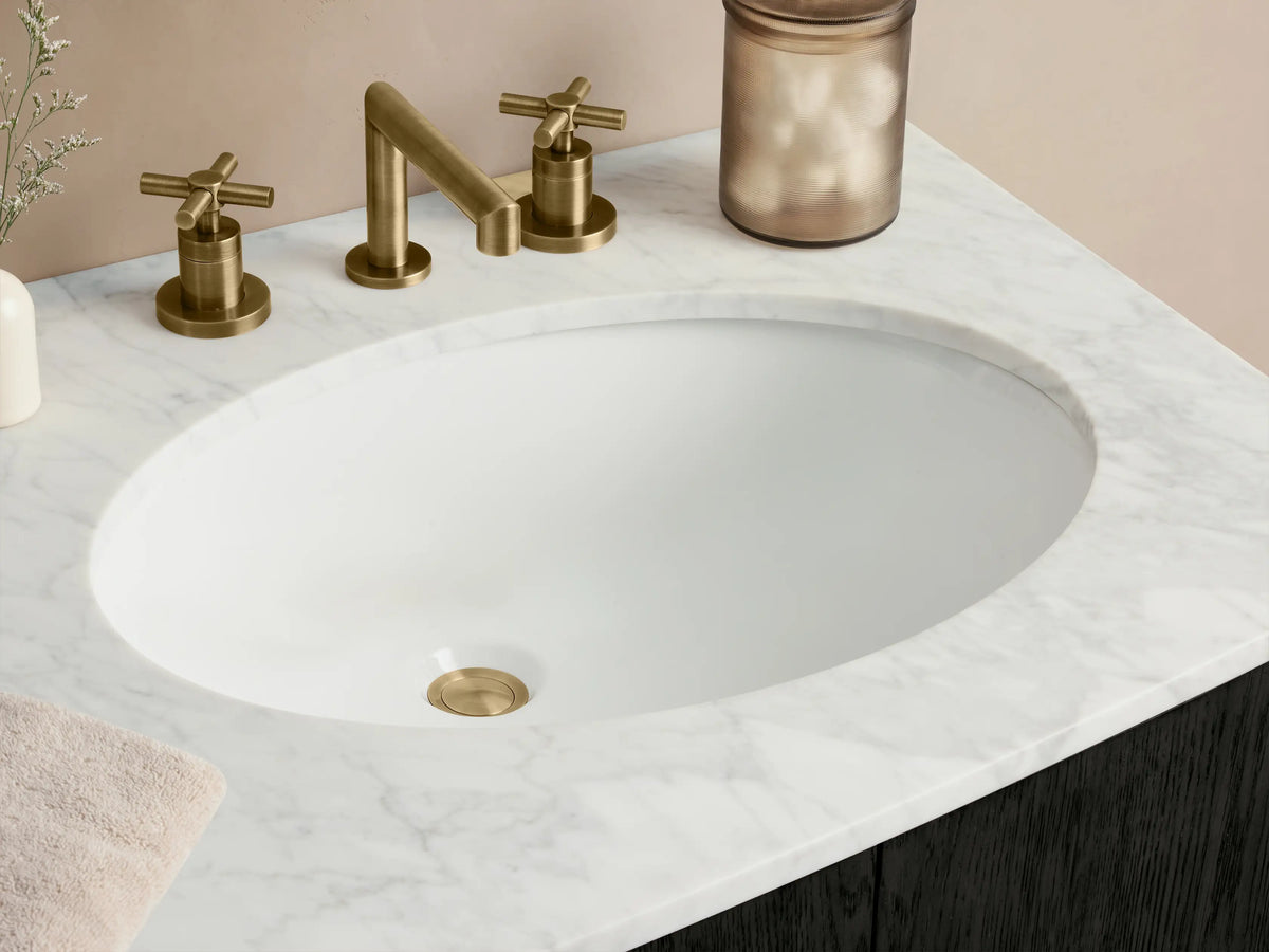 Danny Double Vanity: dark charcoal oak with a curved front, white Carrara marble top with two oval sinks, and brass pulls.