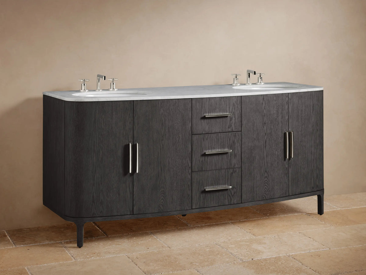 Danny Double Vanity in dark oak wood finish, showing cabinet doors ajar with chrome handles, exposing a shelf with folded towels and a black marble item.