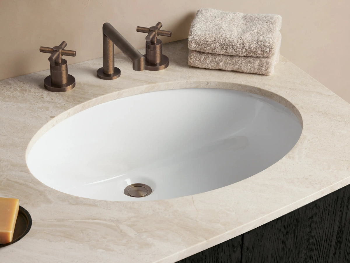 Danny Double Vanity: Curved dark espresso oak double vanity with white marble top, two oval sinks, 4 doors, 3 drawers, bronze pulls.