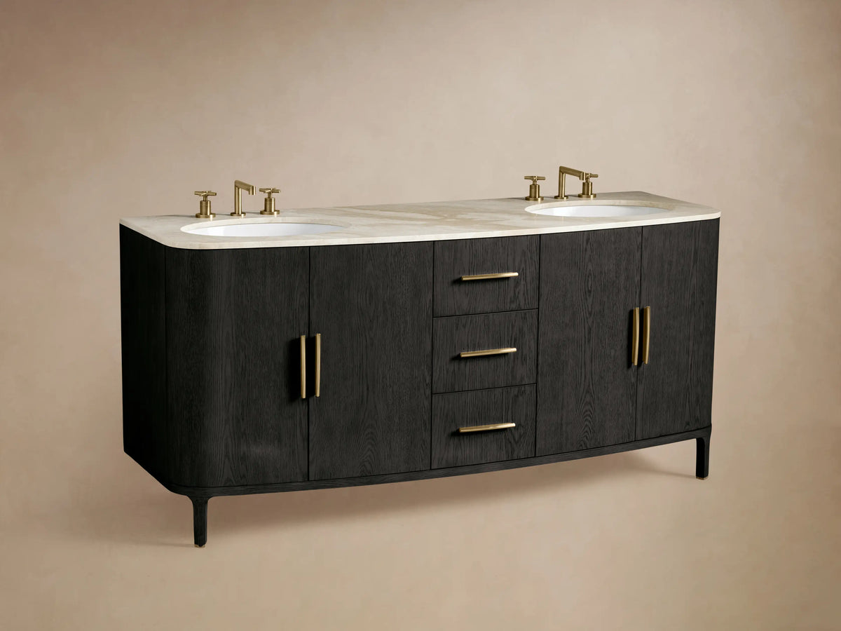 Close-up of open Danny Double Vanity cabinet in dark wood, brass handle, with shelves holding stacked boxes & folded beige towels.
