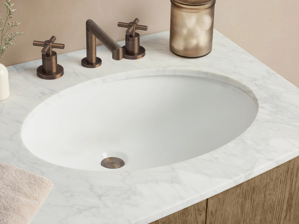 Danny Double Vanity: Light oak double vanity with rounded ends, white marble top, two oval sinks, 2 doors, 3 drawers, dark handles.