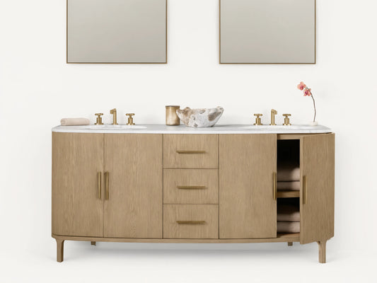 Danny Double Vanity made of oak wood with brass hardware, two sinks, and a marble top. Features multiple drawers and open shelves.