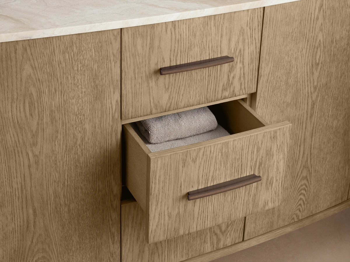 Danny Double Vanity's light oak cabinet, door partially open. Interior shows shelves, folded towels, and a decorative box.