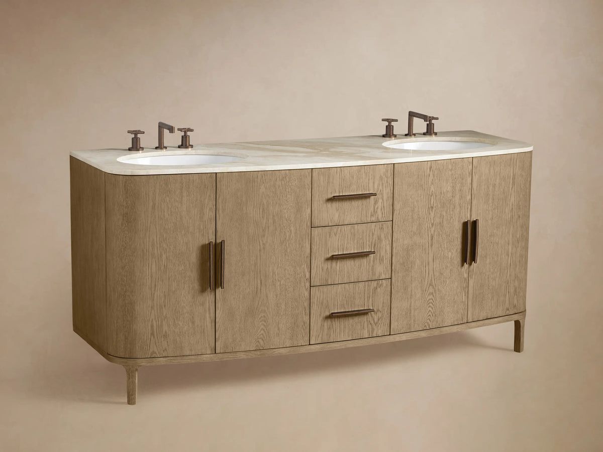 Close-up of light oak Danny Double Vanity with marble top. One drawer is open, revealing grey towels. Features dark brown handles.