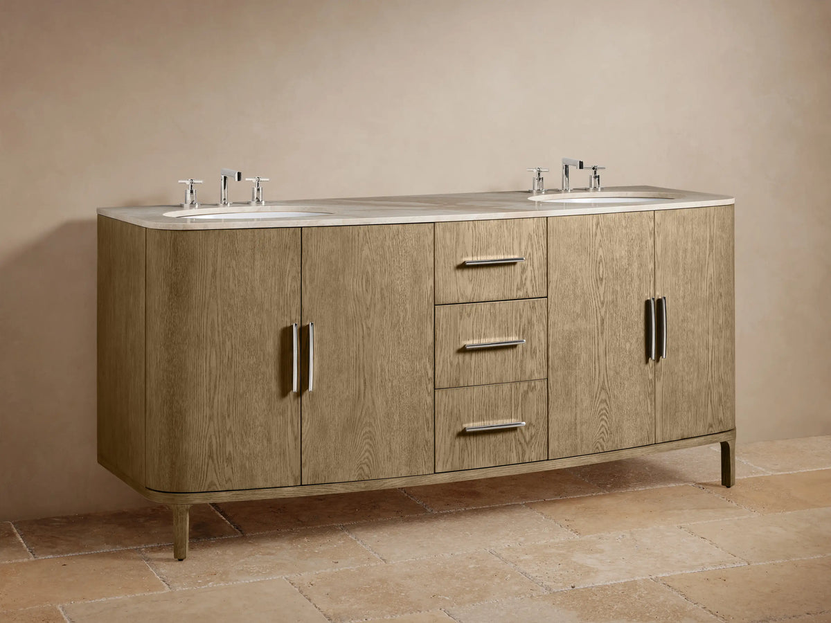 Danny Double Vanity with oak finish features two sinks with silver faucets, three central drawers, and side cabinets, one slightly open, revealing wooden shelves. Two mirrors and decorative items on stone top.