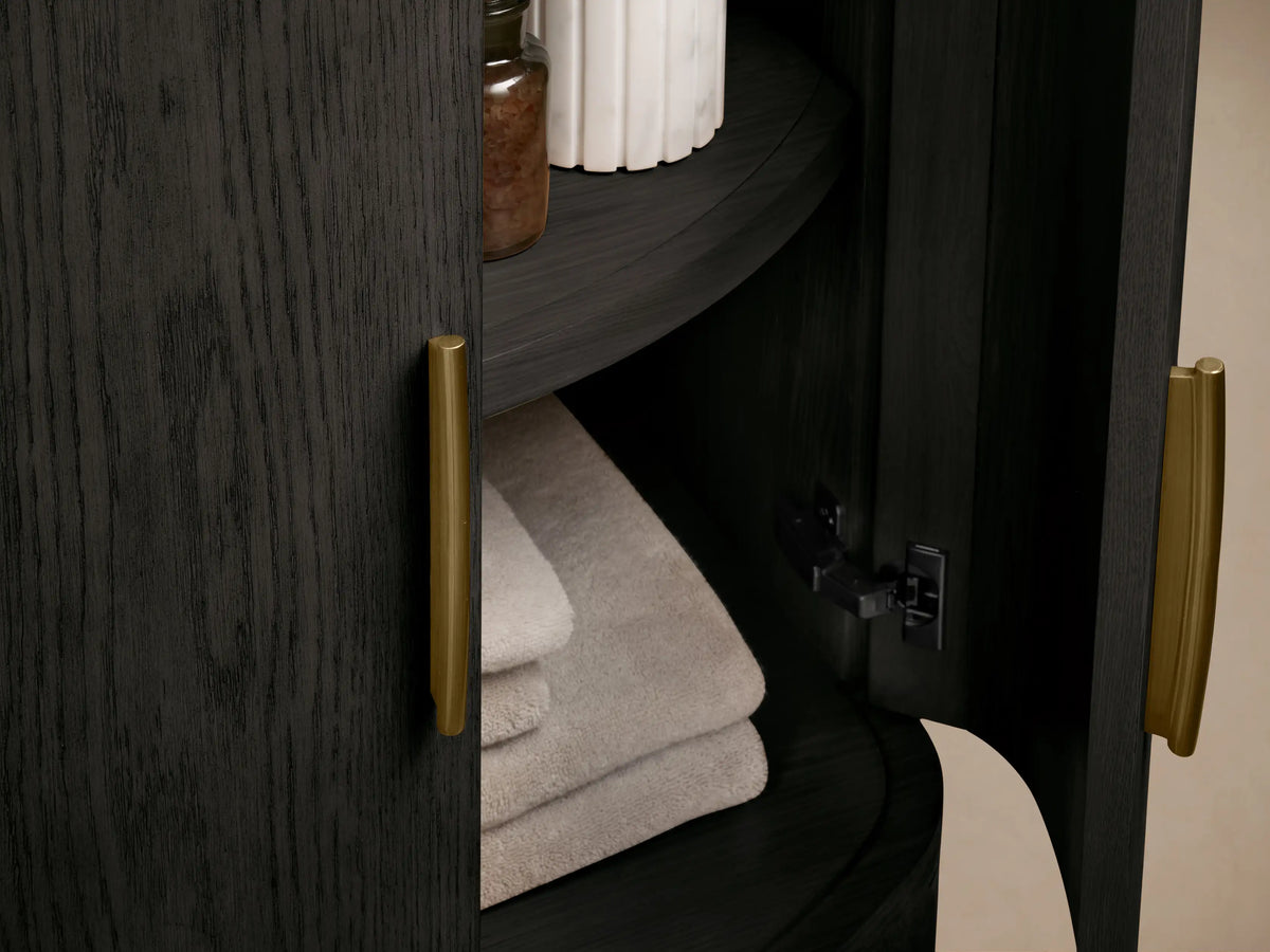 Danny Powder Vanity: White oval sink in veined marble top, antique brass widespread faucet set, bronze vase, and white soap.