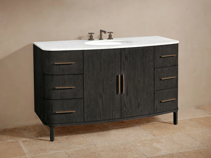 Dark oak Danny Wide Single Vanity with open cabinet door showing towels & bottles on shelves. Bronze handles on door & drawers.