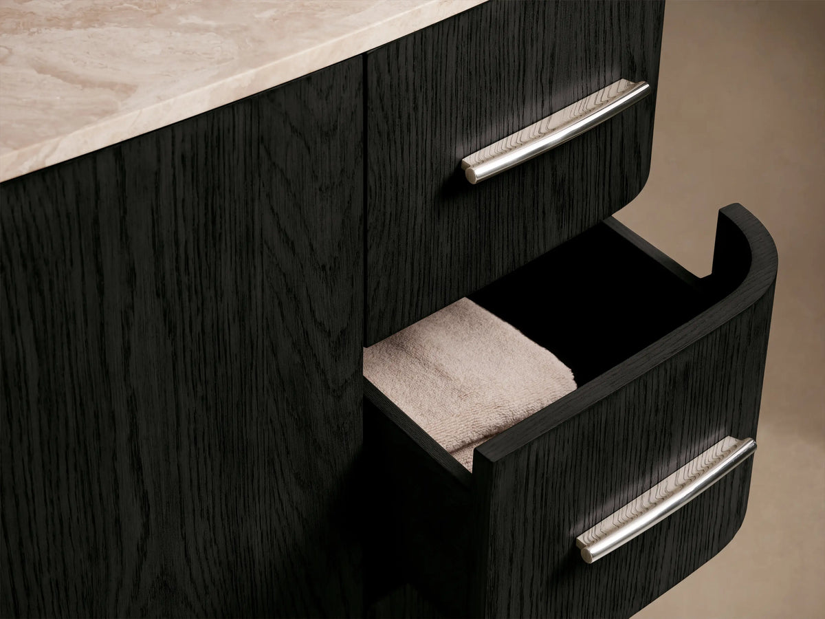 Close-up of Danny Wide Single Vanity: white oval undermount sink, light beige honed stone countertop, chrome faucet, dark wood base.
