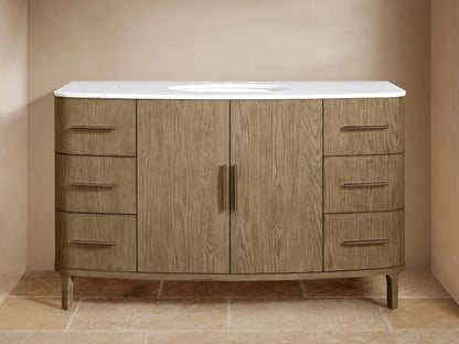 Danny Wide Single Vanity in light brown oak wood with a white marble top and oval sink. Features 2 central doors and 6 drawers with bronze pulls.