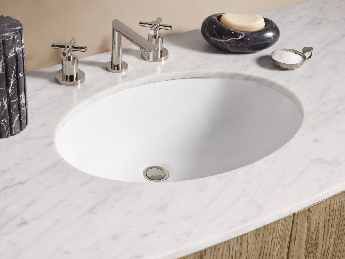 Danny Single Wide Vanity featuring oak wood with a marble top; includes drawers and doors with metallic handles; sink and faucet on top.