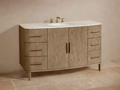 Danny Single Wide Vanity in oak wood with six drawers, two center doors, gold hardware, marble top, and oval sink, against beige wall.
