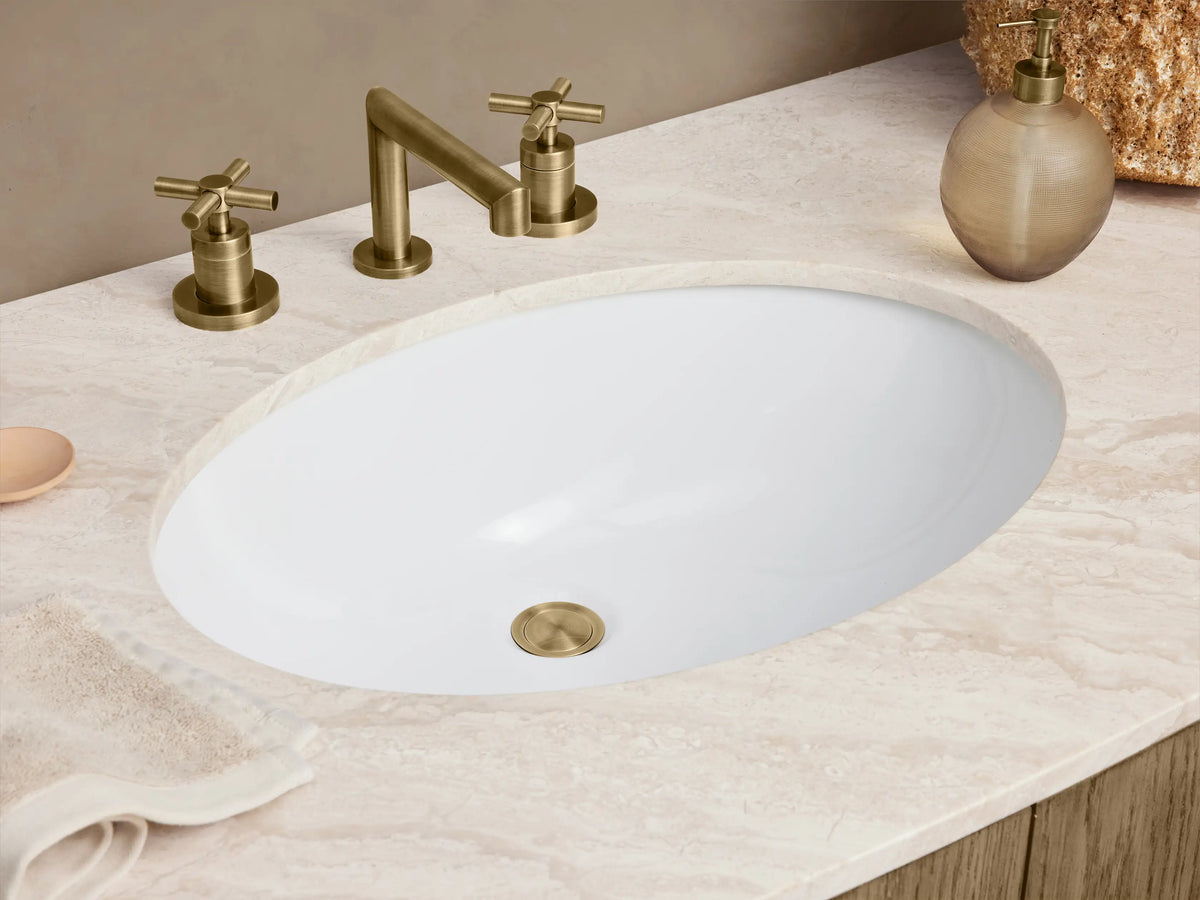 Danny Single Wide Vanity showcasing open oak wood cabinet doors with Antique Brass handles, revealing shelves with neatly folded towels inside.