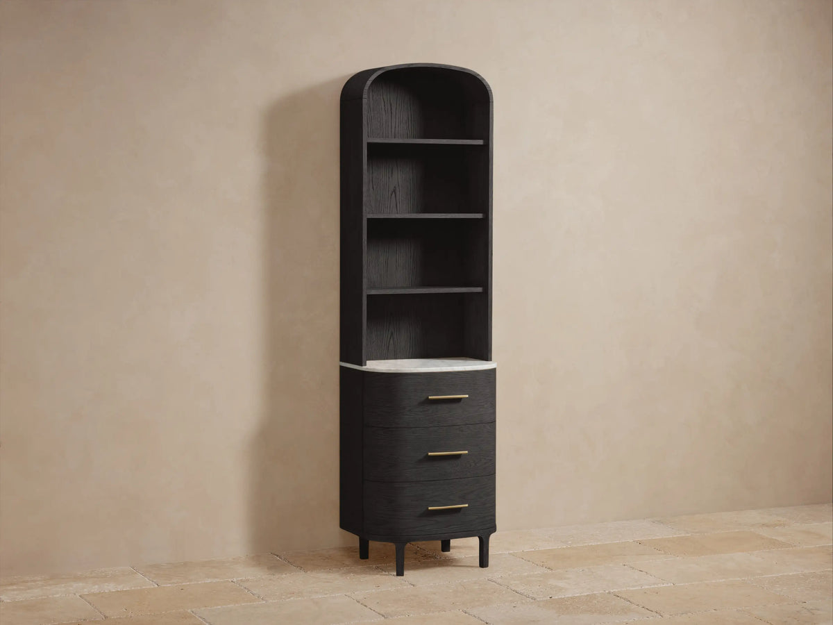 Danny Bath Cabinet: Close-up of dark oak wood shelves. White towels on top shelf, plant & candle on white marble base.