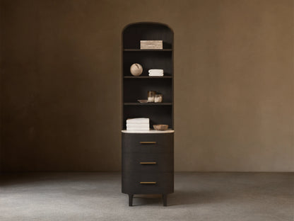 Tall, dark wood Danny Bath Cabinet with arched top, open shelves, white marble counter, and 3 curved drawers with brass pulls.