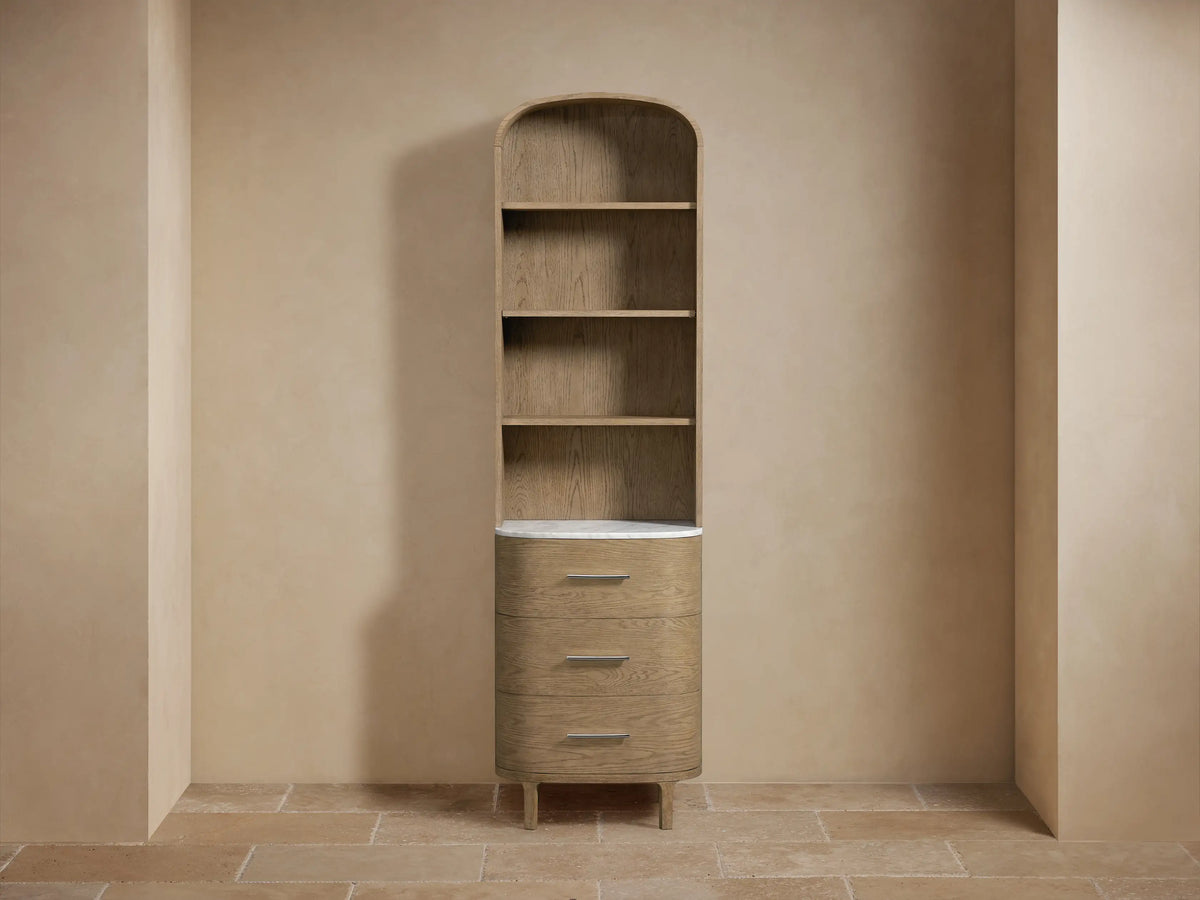 Oak wood Danny Etagere with light brown finish, stone top, two shelves, towels on top, and a decorative item on the bottom shelf.