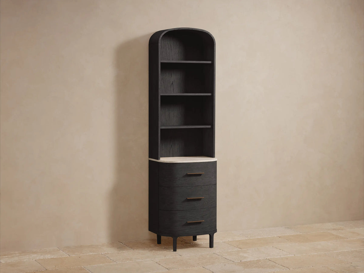 Close-up Danny Bath Cabinet: dark black oak with visible grain, adjustable shelves. Beige towels, dried flowers, marble vase on light top.