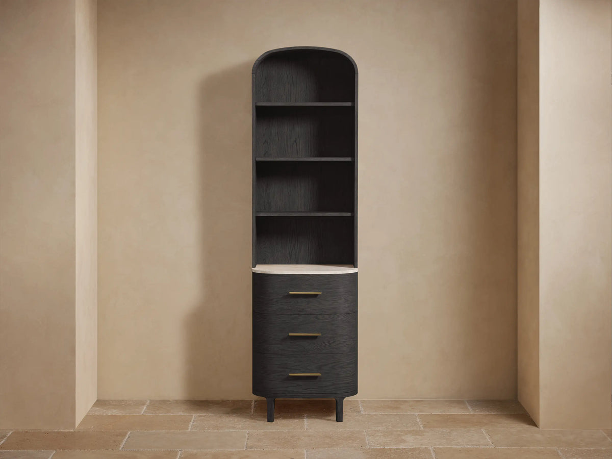 Tall Danny Etagere made of dark oak and marine-grade plywood, with a light stone top. Features open shelves and drawers.