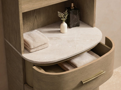Danny Etagere with oak wood and plywood frame, four open shelves, three drawers with brass hardware, and stone top against a beige wall.