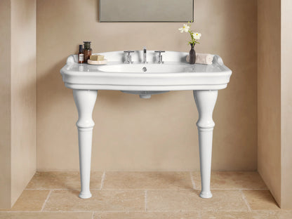 Front view of white ceramic Eloise Single Washstand with integrated sink, sculpted legs, and chrome faucet, in a beige bathroom.