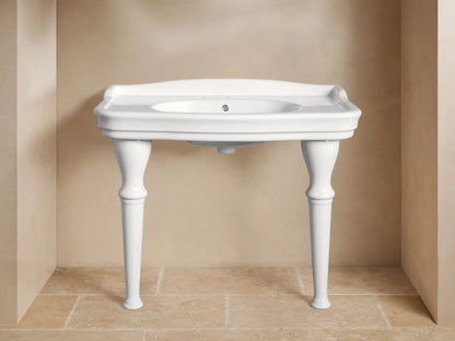 Front view of white ceramic Eloise Single Washstand with integrated sink, sculpted legs, and chrome faucet, in a beige bathroom.