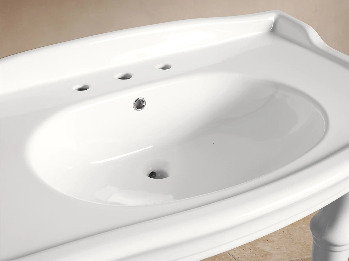 White ceramic Eloise Single Washstand with integrated sink, chrome 3-piece widespread faucet, and bath items on the counter.