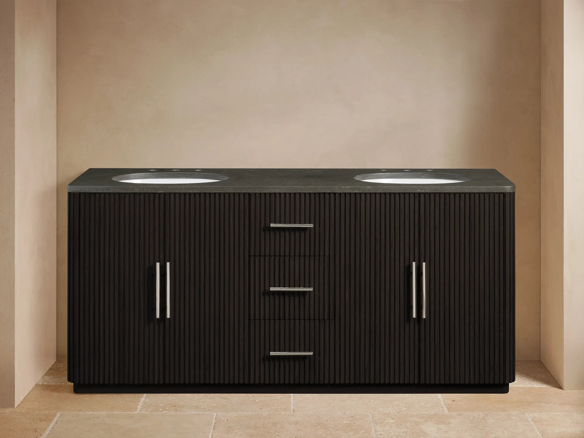 Finnley Double Vanity, dark fluted wood, gray stone top, 2 white oval sinks, chrome faucets & hardware. Left door open, organized bathroom.
