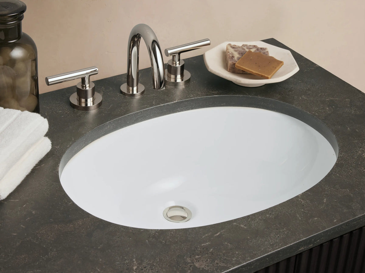 Finnley Double Vanity: Dark fluted cabinet, dark gray bluestone top, two white oval sinks, polished nickel hardware, shown against a light wall.