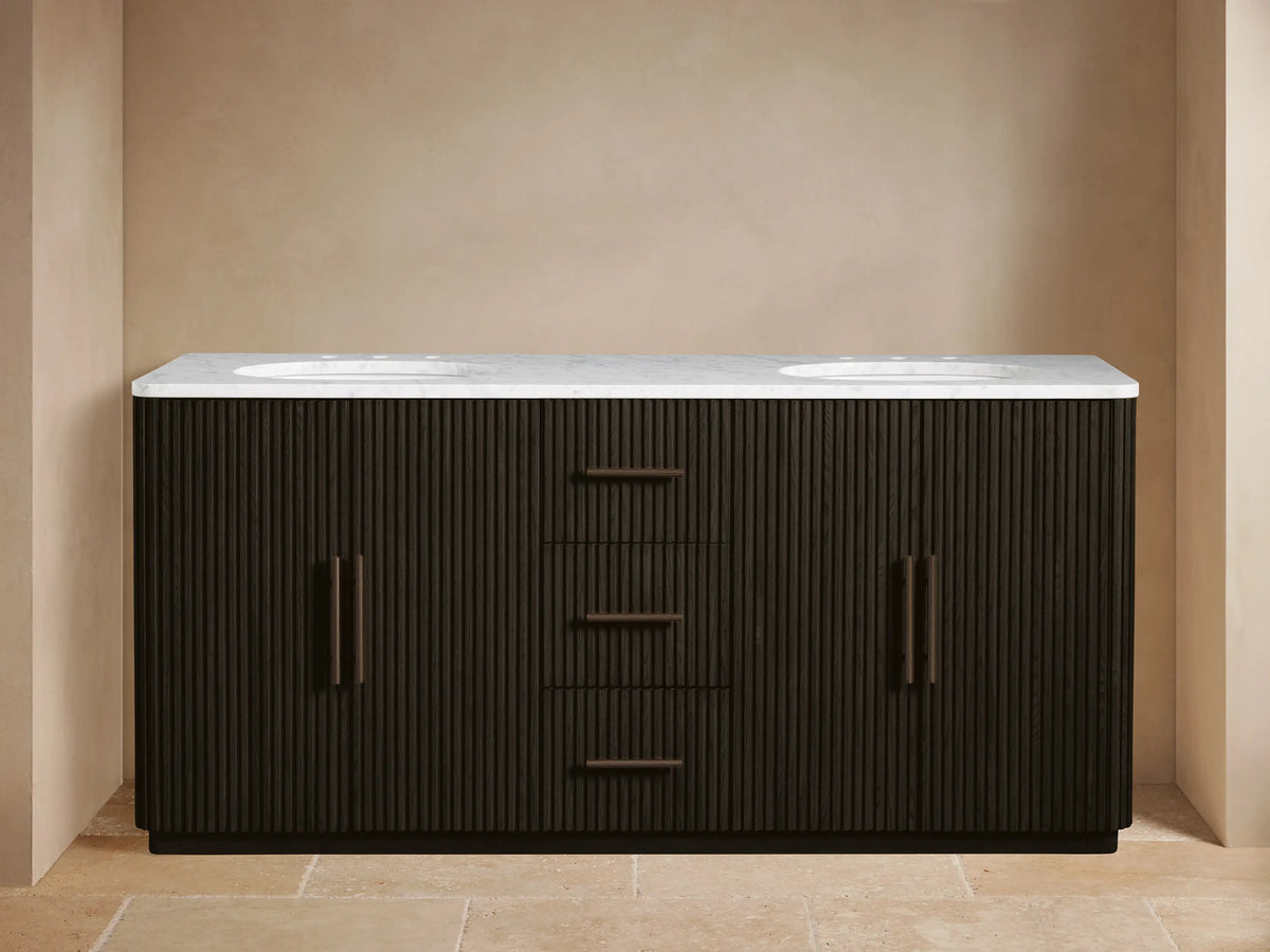 Finnley Double Vanity: Dark brown fluted cabinet with white marble top, two oval sinks, bronze faucets. Left door open, showing towels.