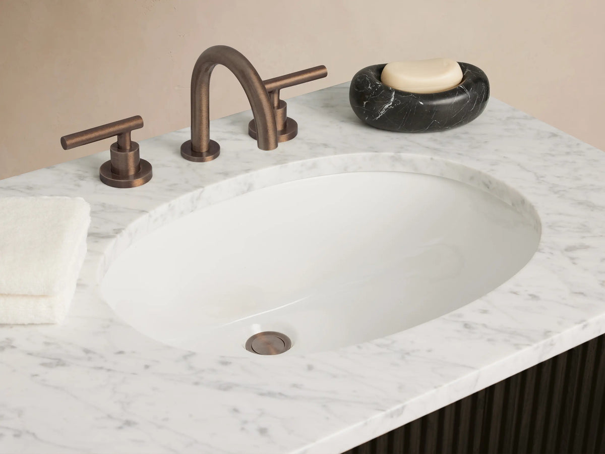 Front view of Finnley Double Vanity. Dark brown fluted cabinet with white marble top, two oval sinks, bronze bar handles.