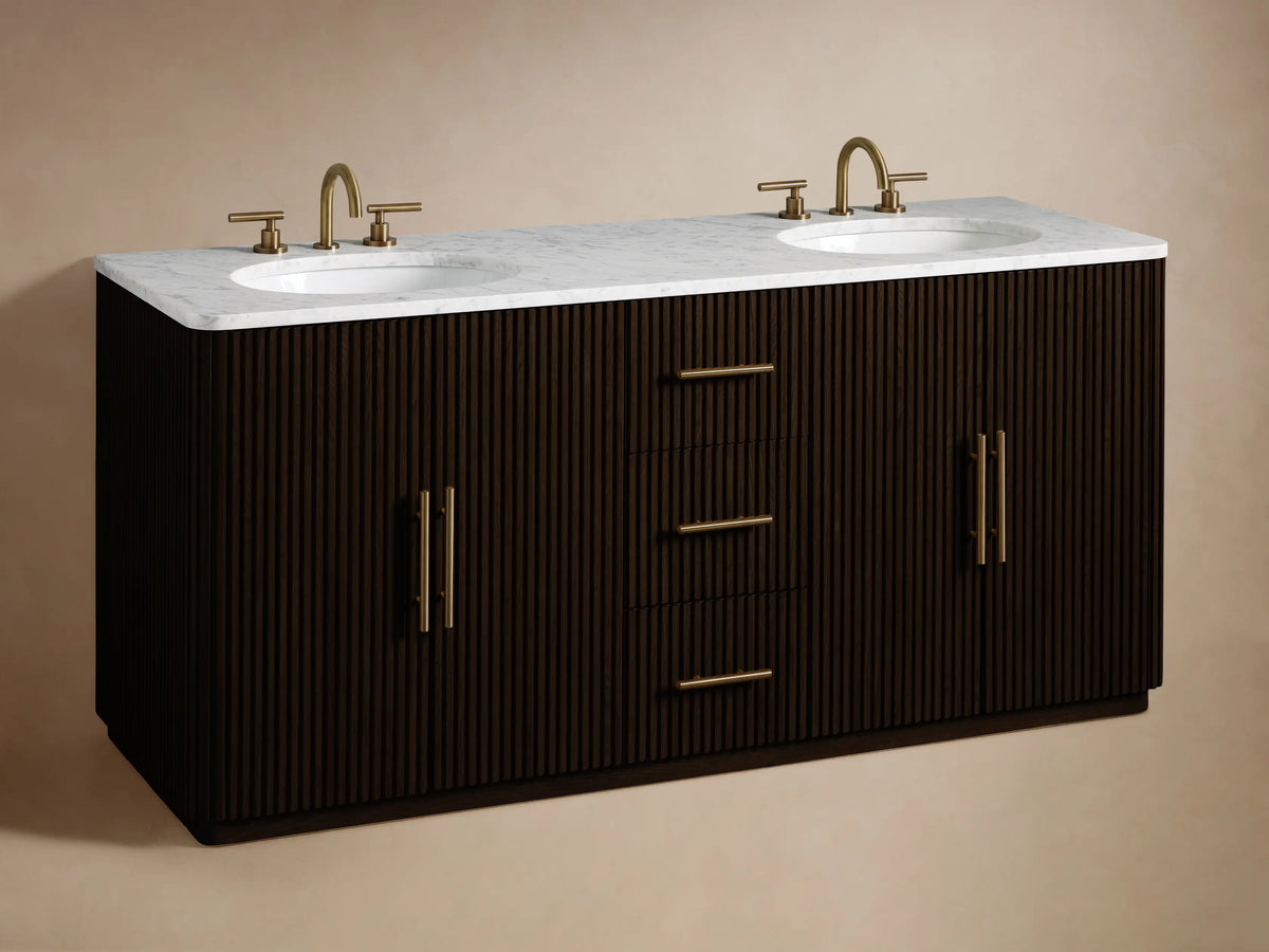 Angled close-up of dark fluted Finnley Double Vanity. Bottom drawer slightly open, a folded light towel inside. Gold bar pull handles.
