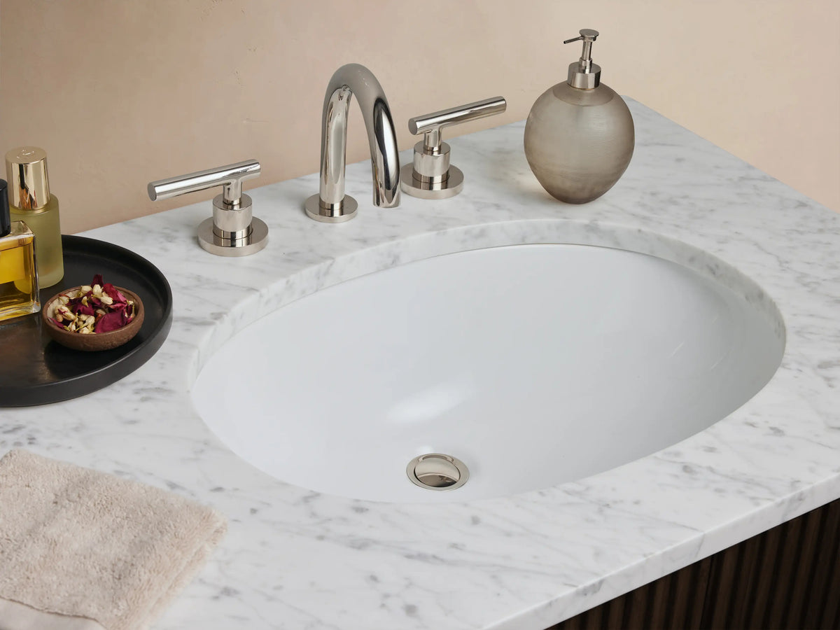 Finnley Double Vanity, dark brown wood with ribbed panels, white marble top, two oval sinks, and polished nickel hardware.