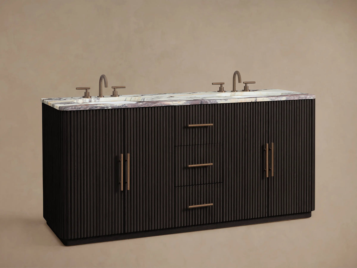 Finnley Double Vanity: dark ribbed wood base, white marble top with purple veins, 2 bronze faucets, 1 open cabinet with towels.