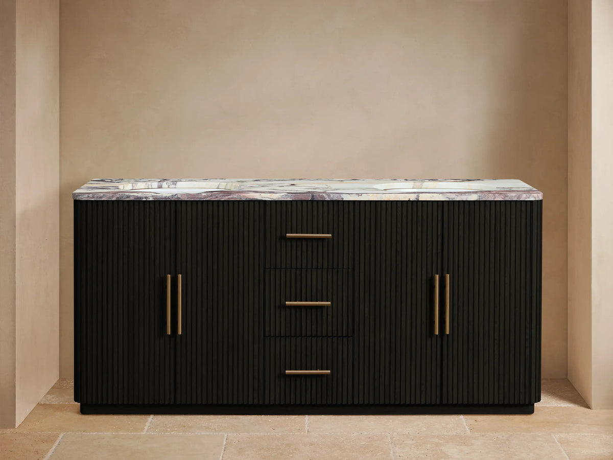 Black fluted Finnley Double Vanity with veined marble top, two sinks, gold faucets, and open left door revealing towels.