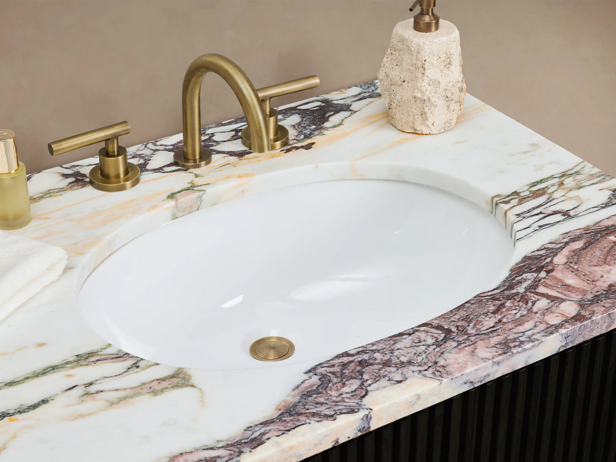 Finnley Double Vanity: Black fluted cabinet, purple-veined marble top, brass hardware. Centered against beige wall on tiled floor.
