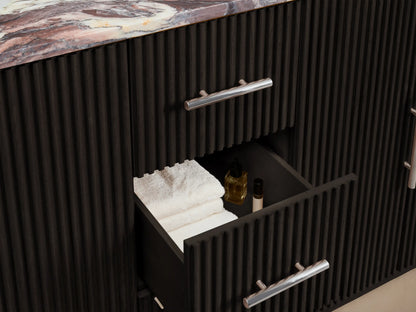 Close-up of Finnley Double Vanity. Dark fluted door with polished nickel handle, open to reveal interior shelf with white towels, stone dish.