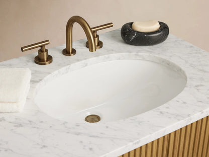 Finnley Double Vanity with ribbed oak wood finish, dual oval ceramic sinks, marble top, and antique brass hardware in a minimalist setting.