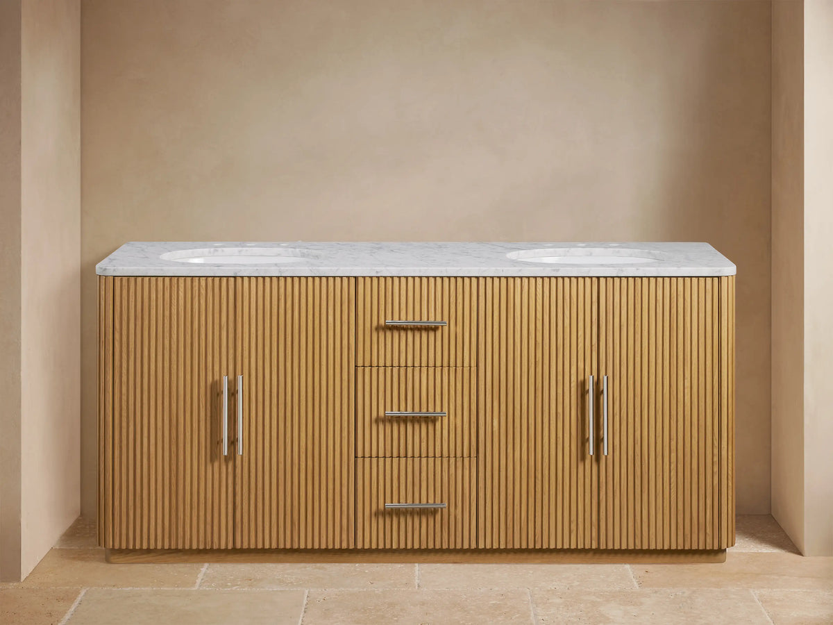 Finnley Double Vanity with oak wood finish, Carrara marble top, two oval sinks, open cabinet displaying contents, three central drawers.