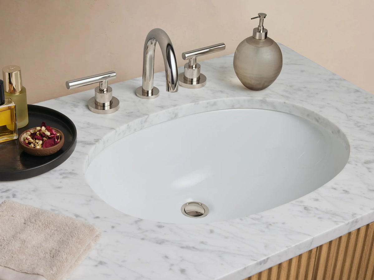 Finnley Double Vanity with vertical slatted oak wood design, Carrara marble top, dual oval sinks, and metallic handles, set against a neutral backdrop.