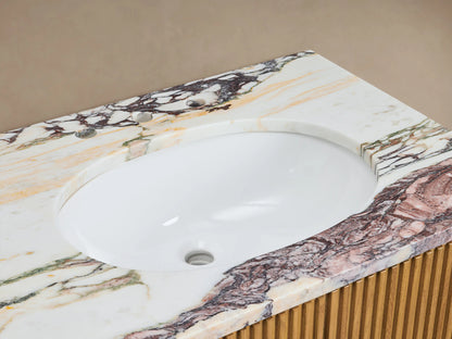 Close-up of Finnley Double Vanity's marbled countertop with white oval sink, bronze faucet, stone dispenser, and ribbed wood.
