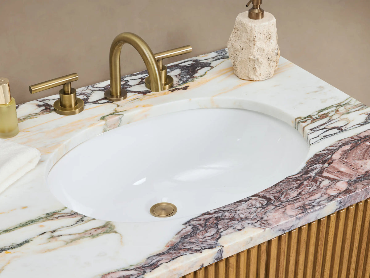 Finnley Double Vanity: Light oak wood with fluted doors, 3 central drawers, antique brass pulls, and purple-veined marble top.