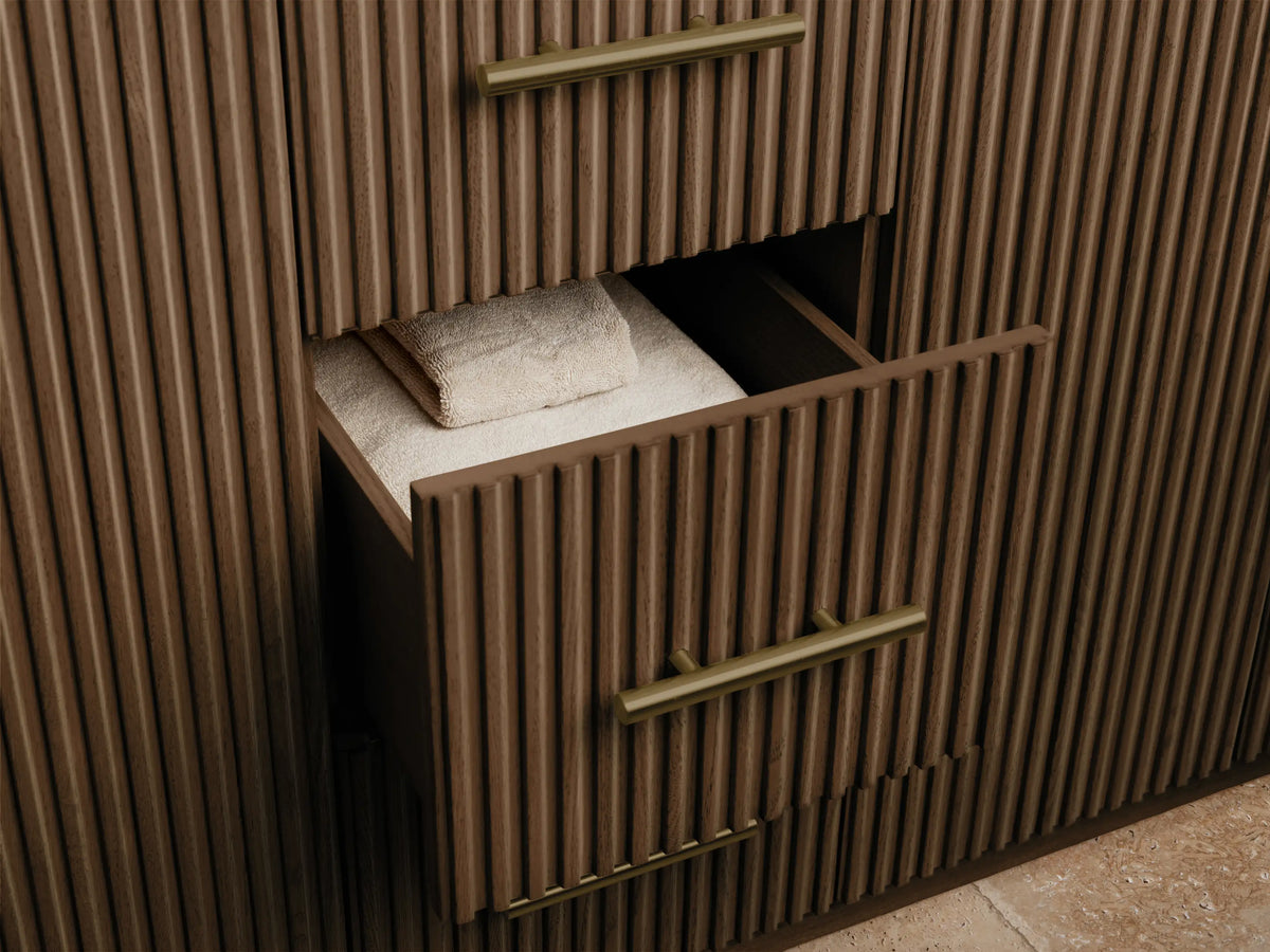Finnley Double Vanity, close-up of a partially open dark wood door with vertical fluting & brass pull, showing white towels & a sponge on a shelf.