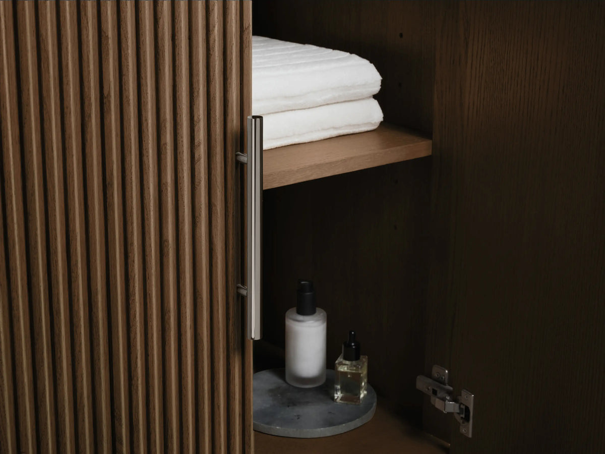 Close-up of Finnley Double Vanity showing an open drawer with white towels, a bottle, dark brown fluted panel, and dark gray stone top.