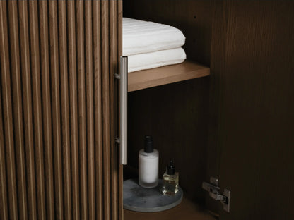 Close-up of Finnley Double Vanity showing an open drawer with white towels, a bottle, dark brown fluted panel, and dark gray stone top.