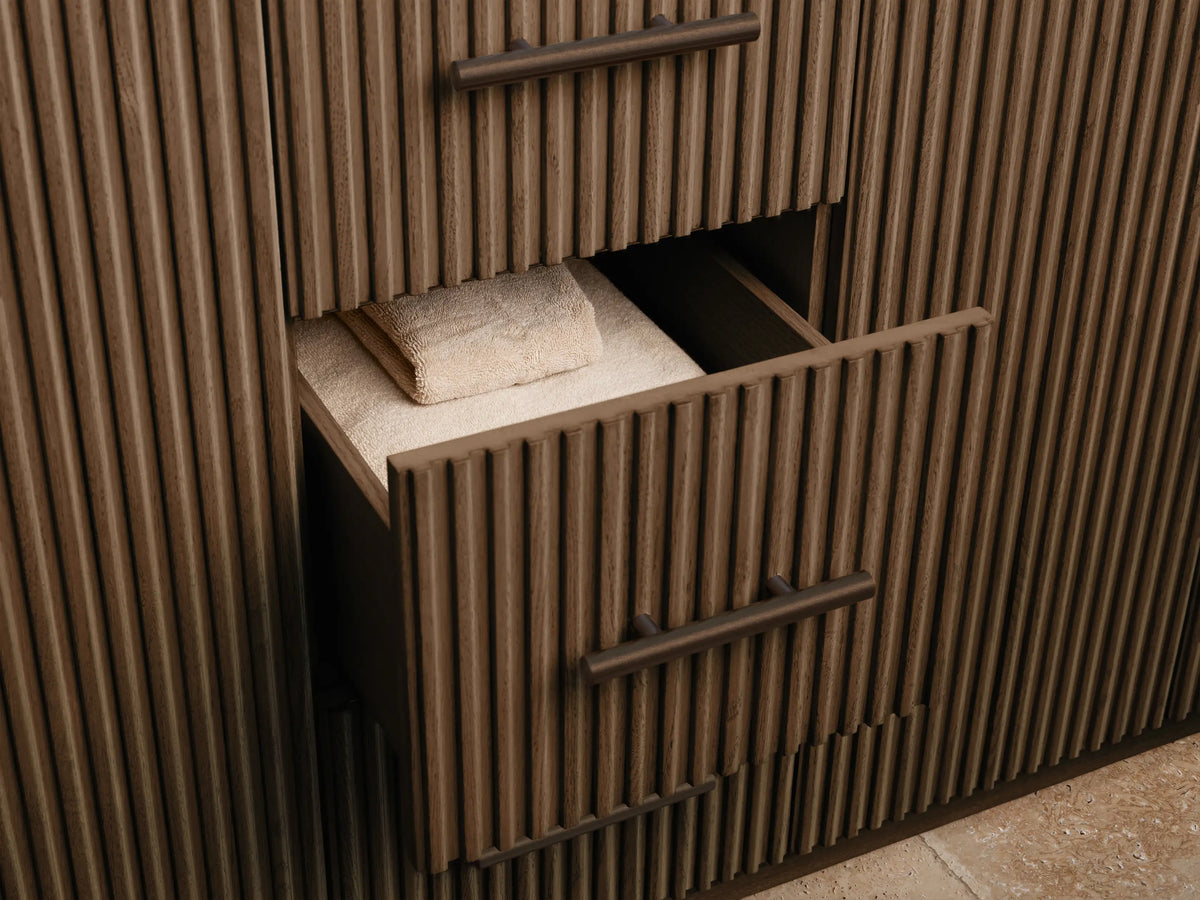 Finnley Double Vanity close-up: white oval sink, veined marble top, bronze faucet, towel, black soap dish, dark wood slats.